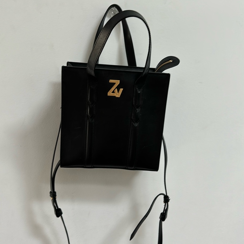 black leather handbag with detachable straps. Zipper with inside pocket